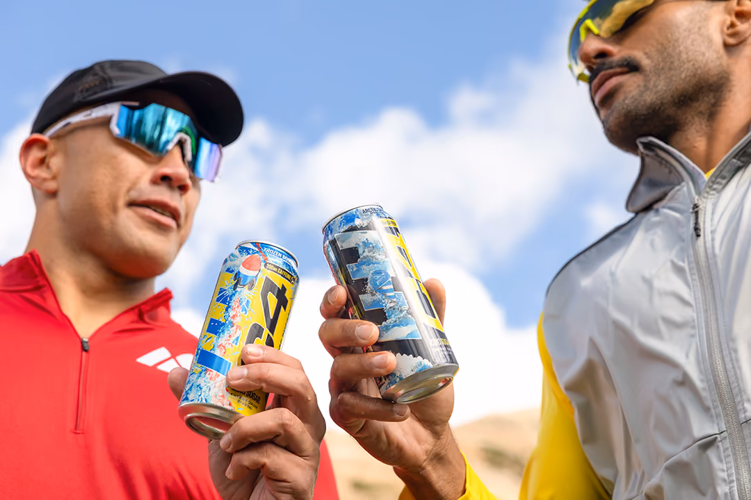 Two men holding C4 energy drinks they got from Maverik gas station