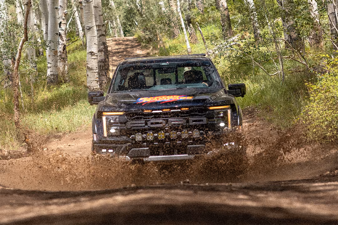 Raptor Rampage prize vehicle splashing through a mud puddle on the trail